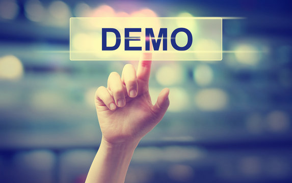 Hand pointing to the word 'DEMO' on a transparent screen.